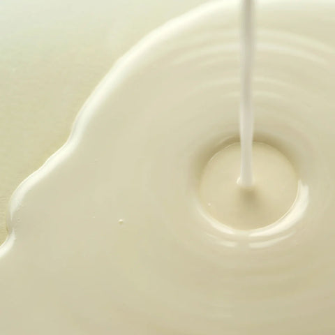 Axis-Y Dark Spot Correcting Glow Toner texture reference. The image shows a milky liquid that is being poured.